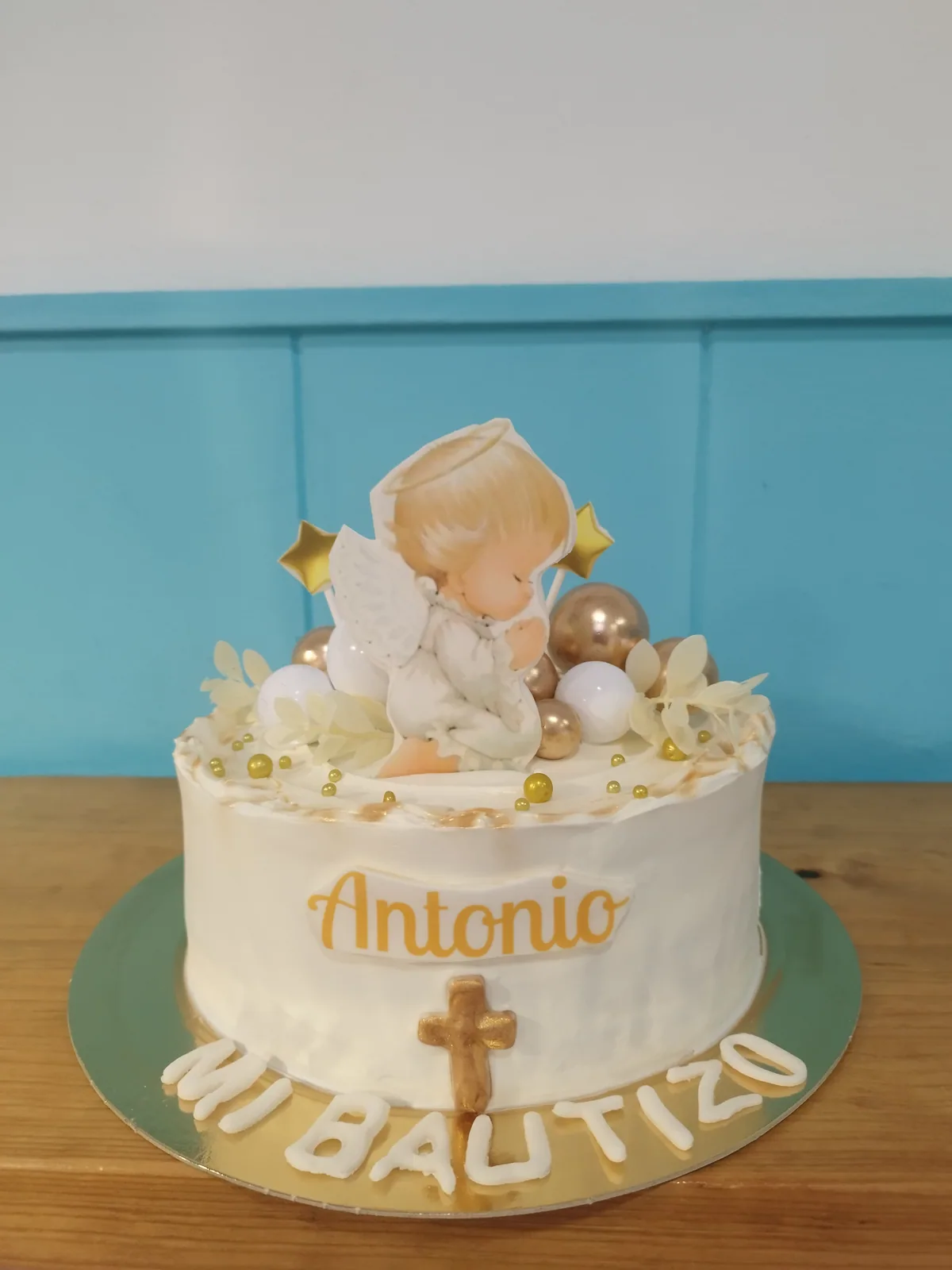 Tarta de bautizo en crema con bebé dormido sobre nubes y nombre personalizado