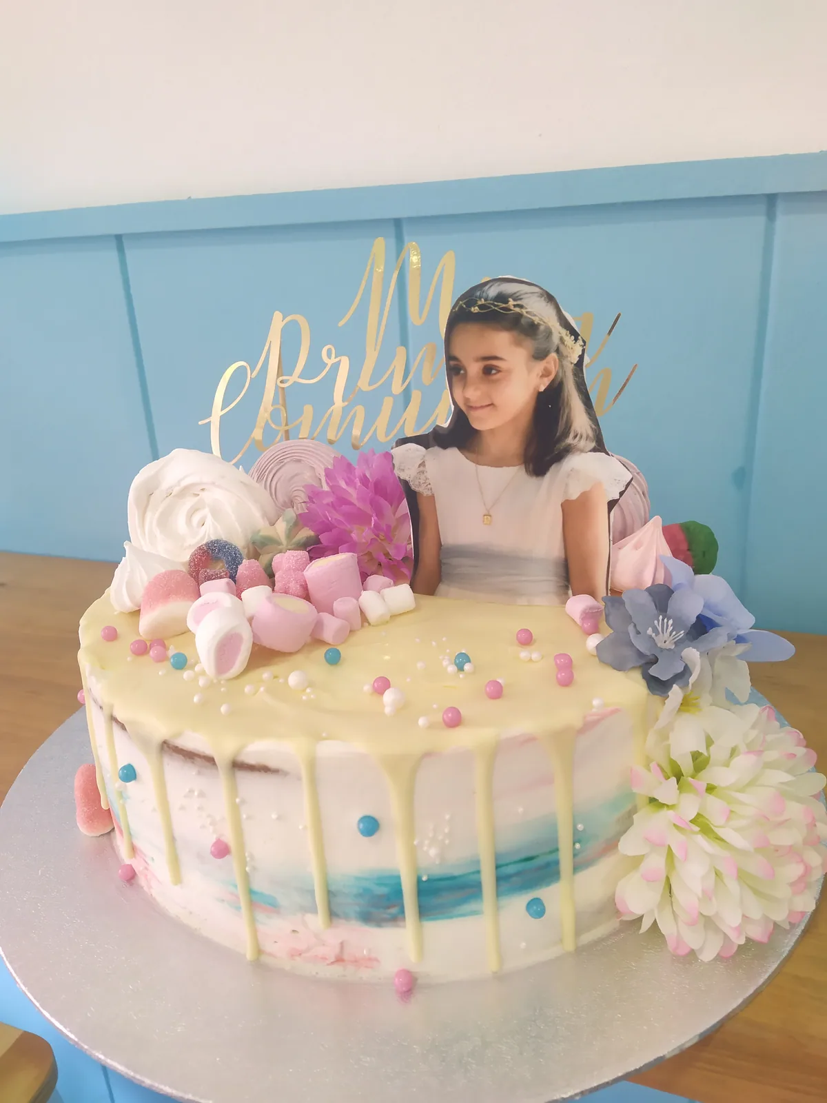 Tarta de comunión con figura de niña, flores y detalles en rosa y blanco