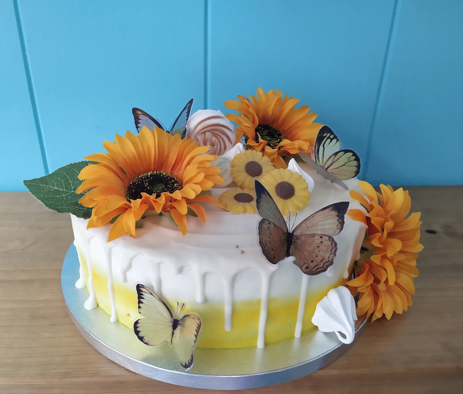 Tarta con girasoles de fondant, mariposas y drip amarillo