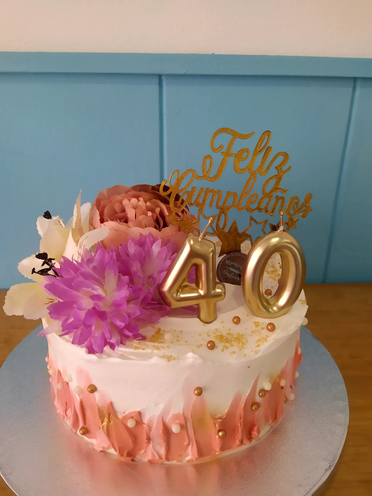 Tarta con drip rosa, flor natural morada y el número 40 dorado