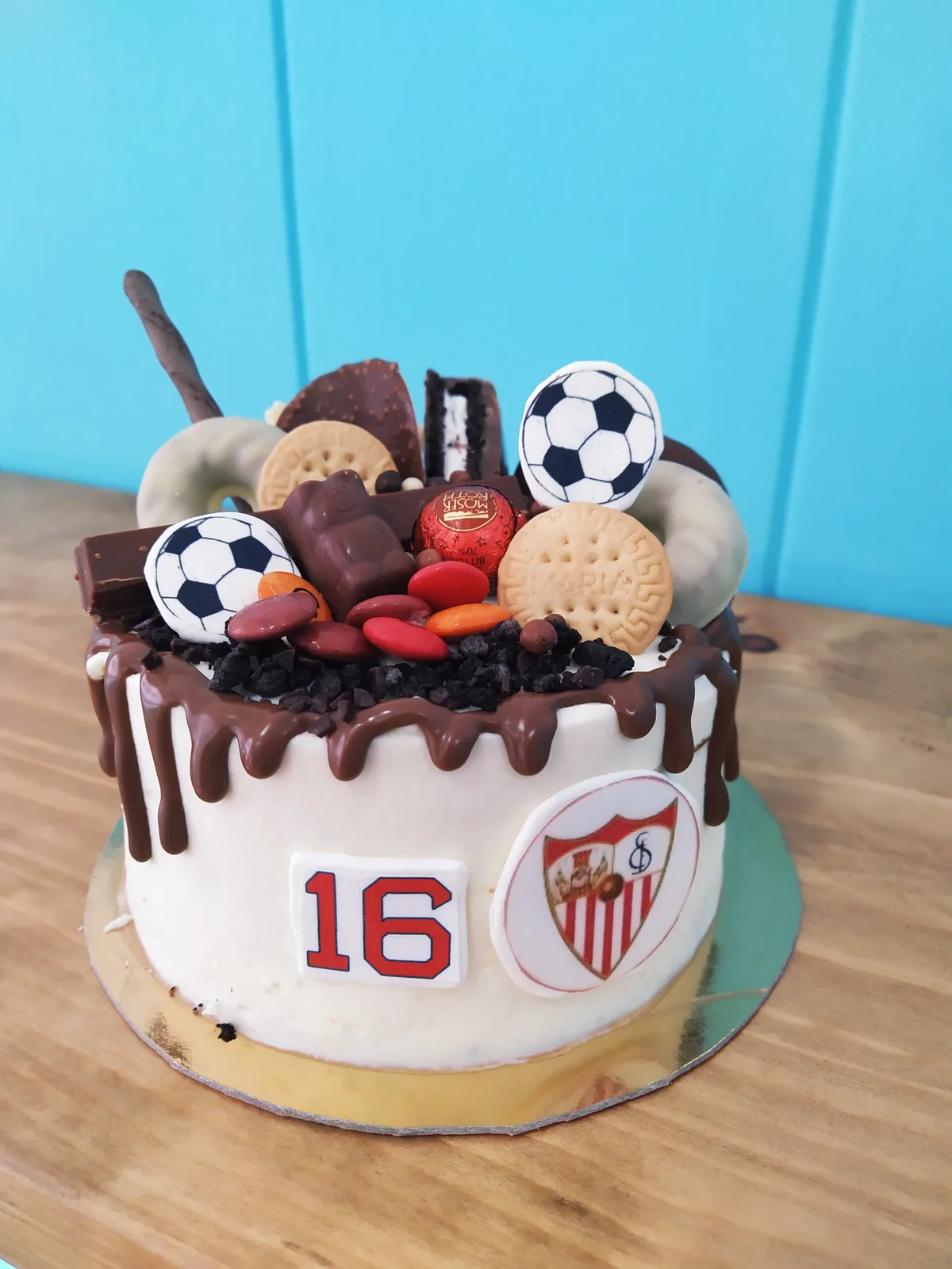 Tarta del Sevilla FC en blanco y rojo con balones de chocolate y el escudo