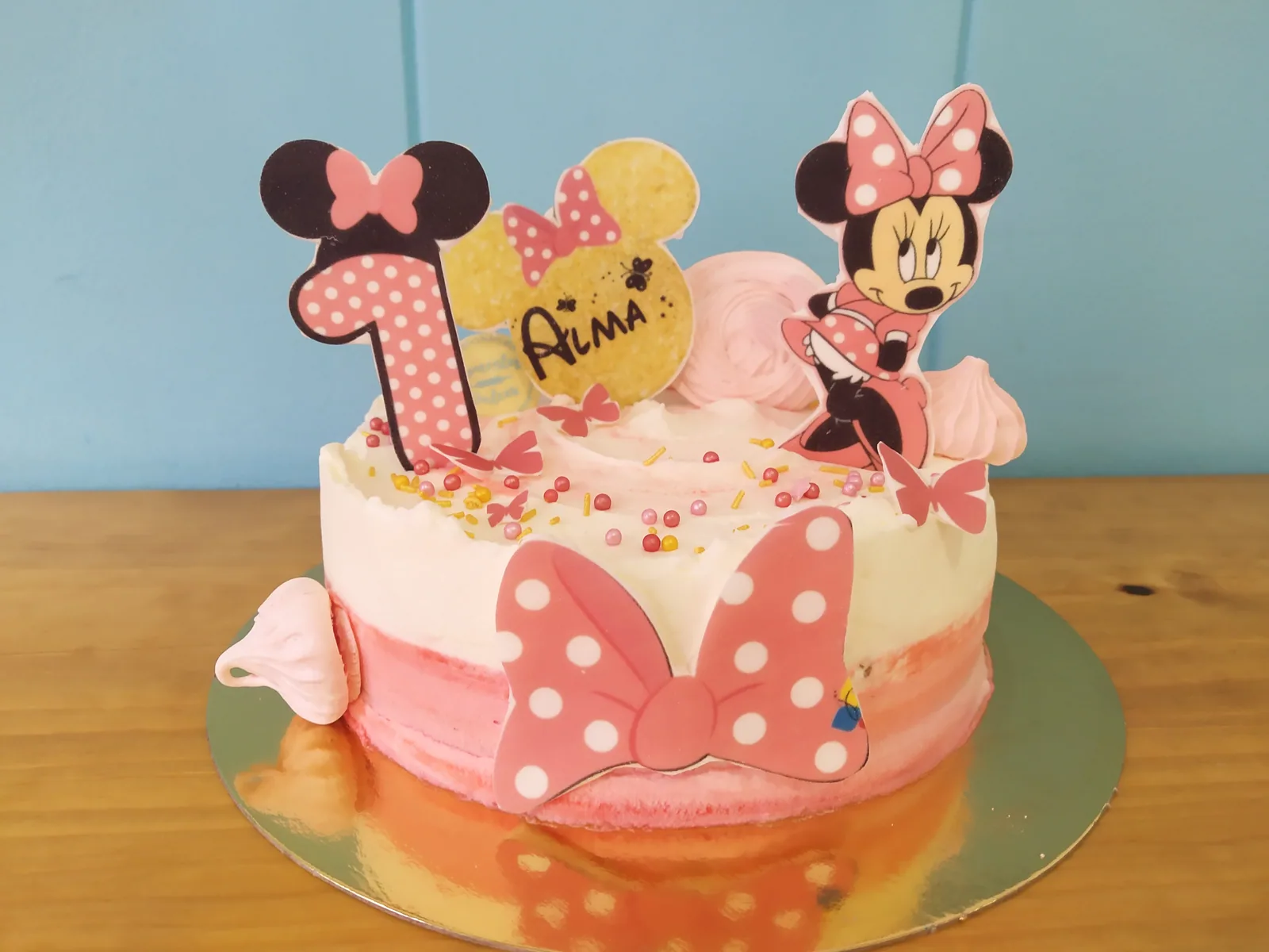 Tarta de Minnie Mouse en rosa con el número uno y lazo grande