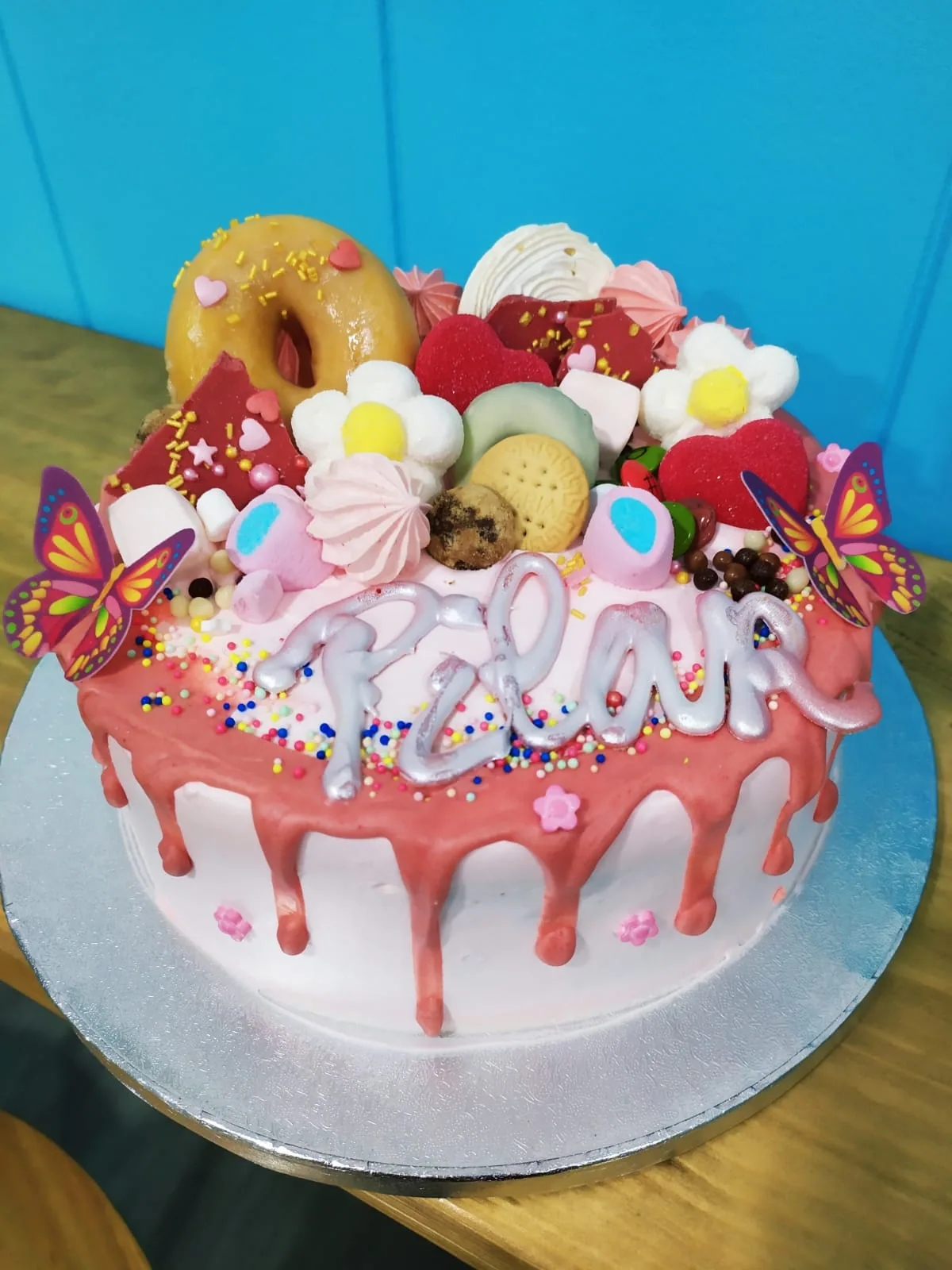 Tarta con drip rojo y media luna de macarons, merengues y frutas