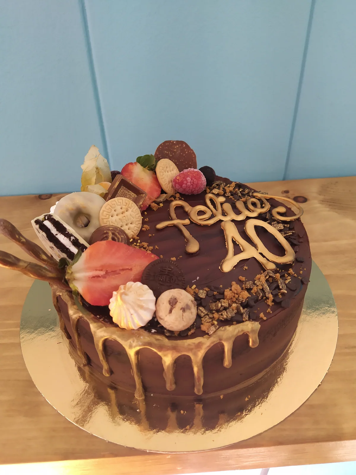 Tarta con drip de chocolate, fresas y frutos rojos en media luna