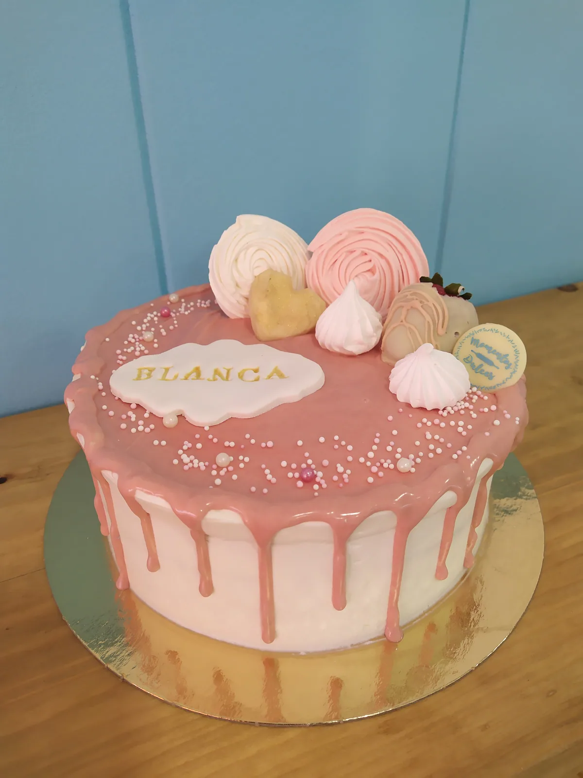 Tarta rosa con drip blanco y merengues en la parte superior