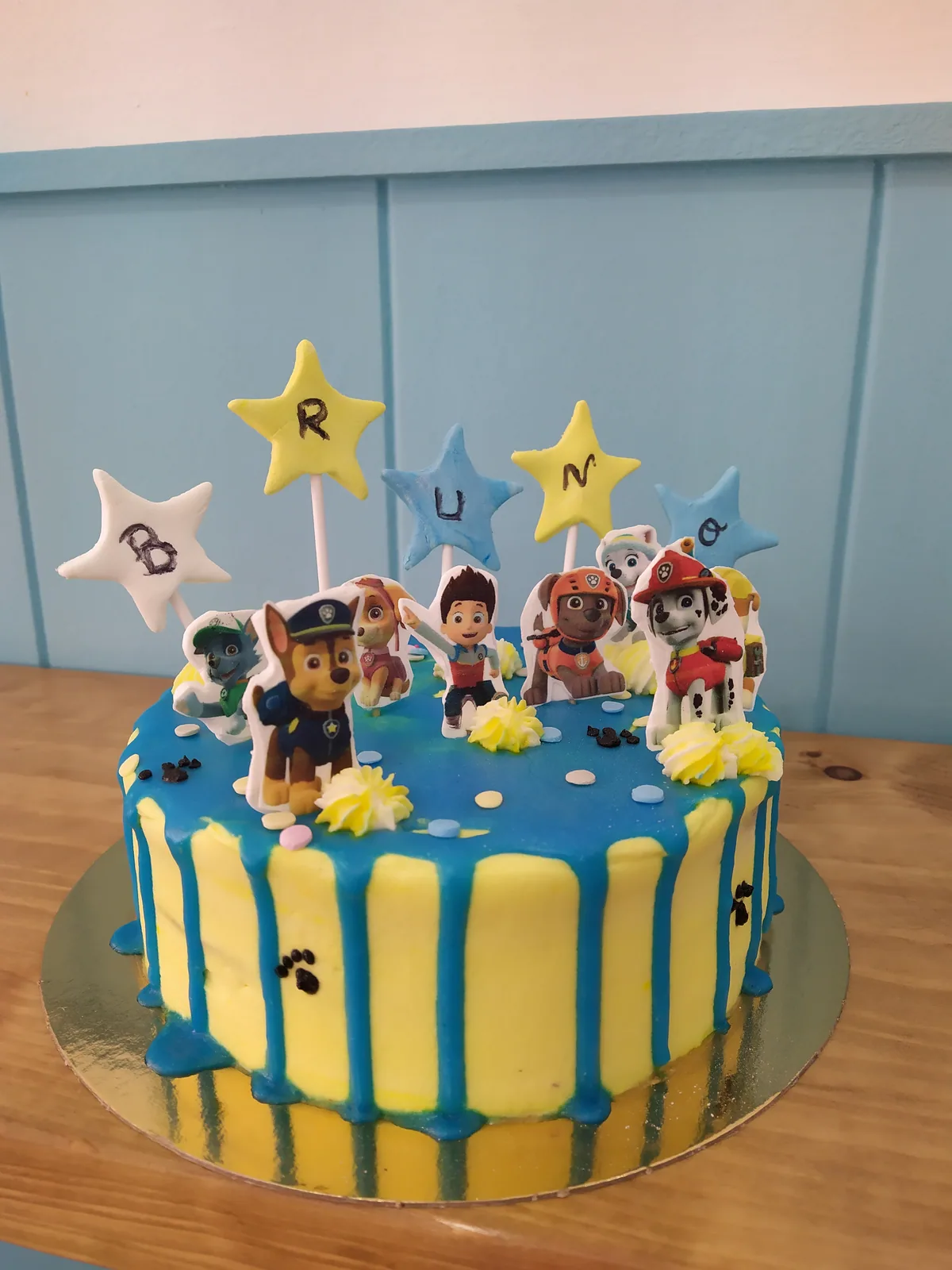 Tarta de la Patrulla Canina en azul y amarillo con drip y los personajes arriba
