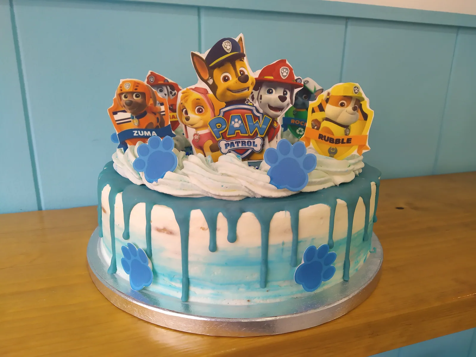 Tarta de la Patrulla Canina celeste con drip blanco y los personajes