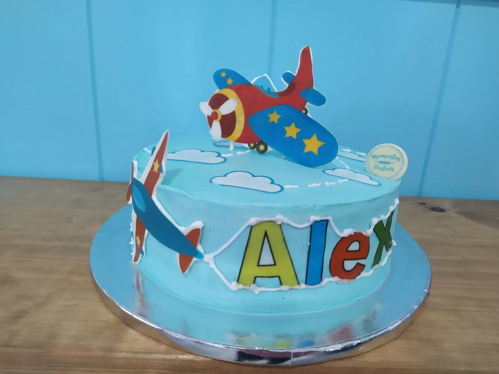 Tarta de primer añito azul con avioneta de fondant y nubes