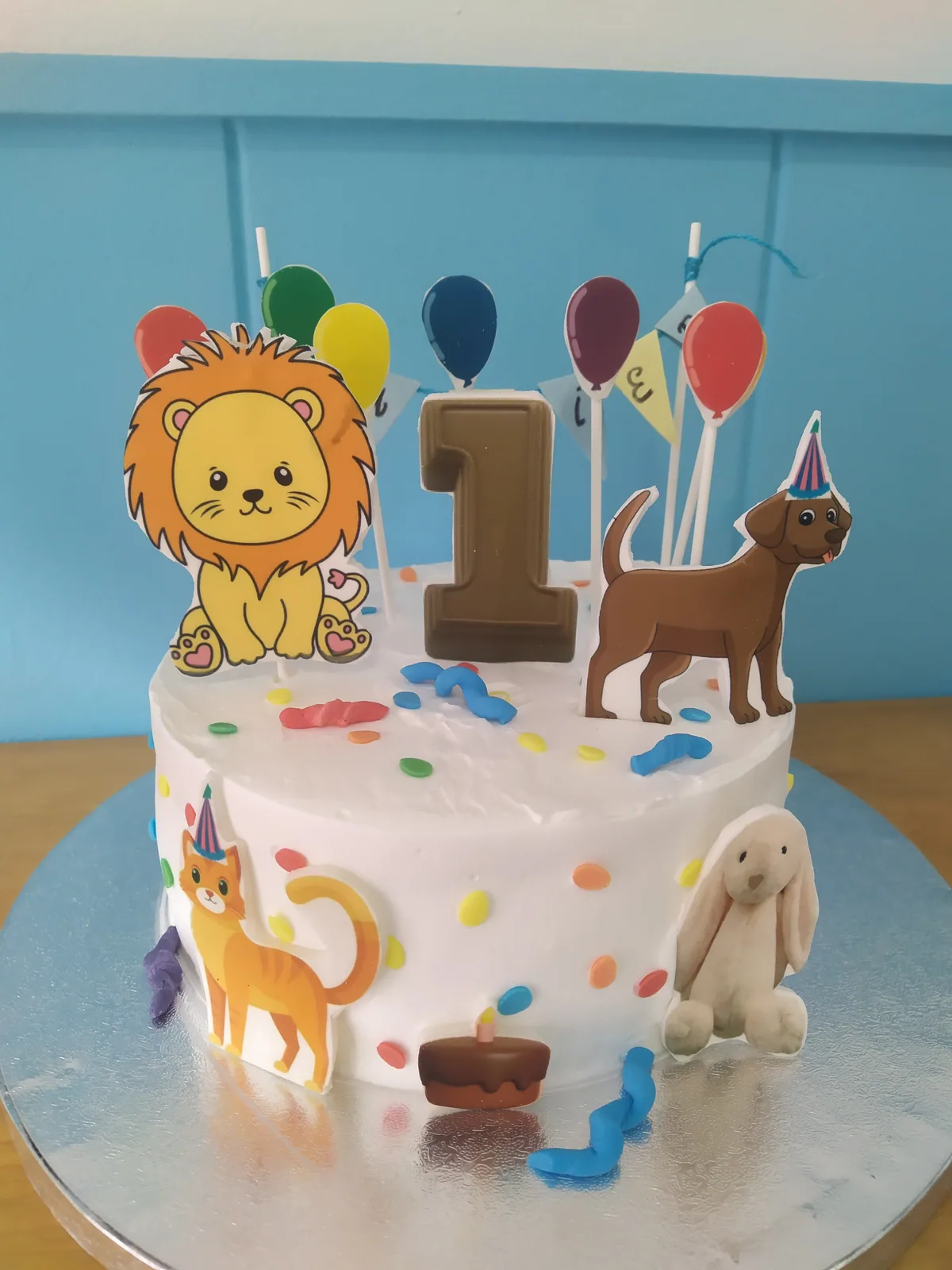 Tarta de primer añito con leoncito, globos y guirnalda de fondant
