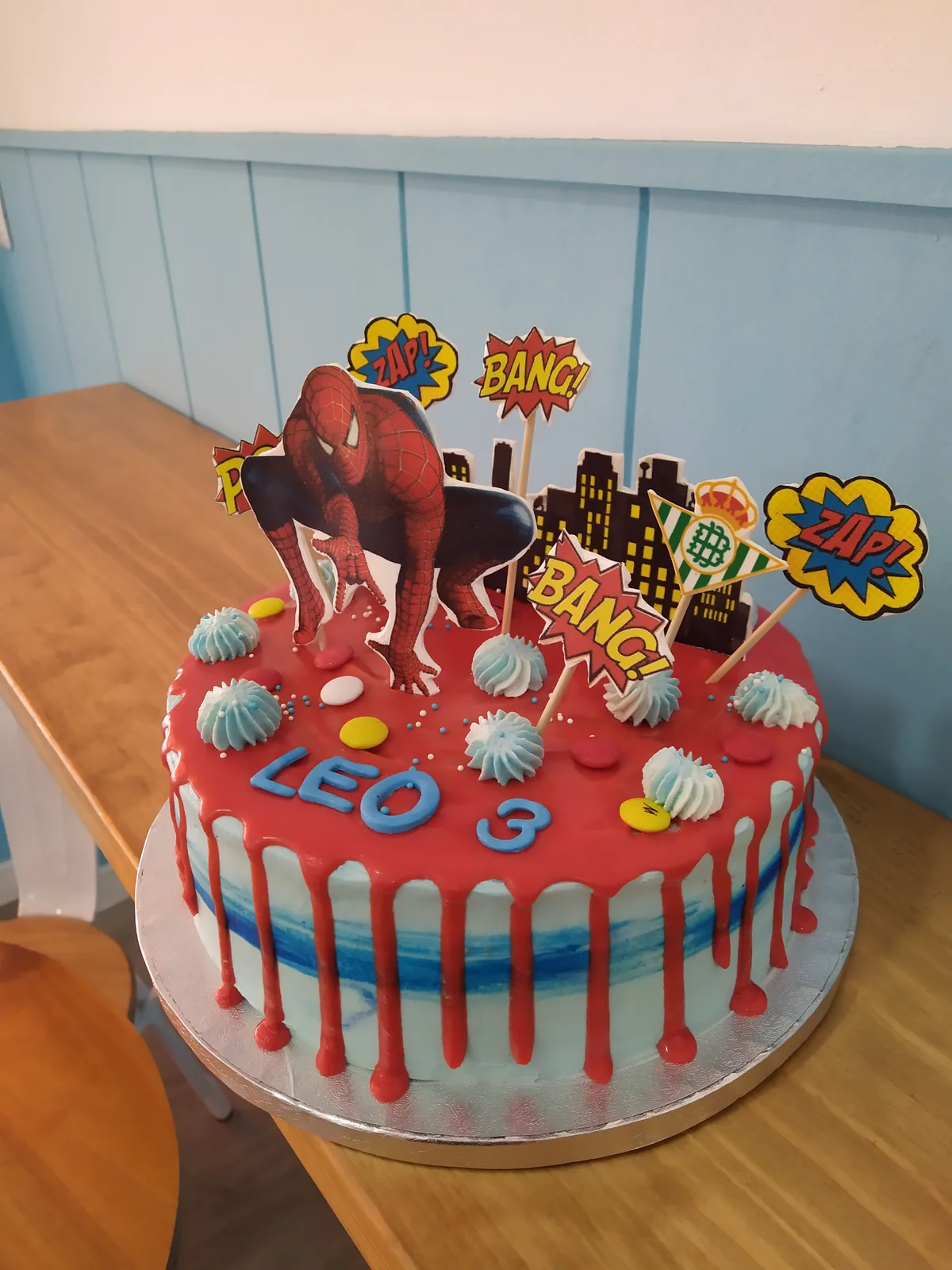 Tarta de superhéroes con drip rojo, viñetas de cómic y personajes