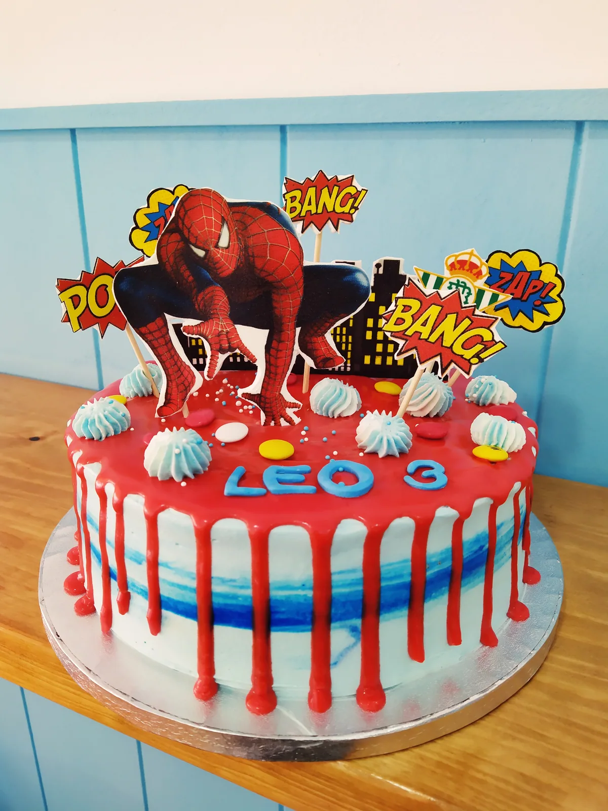 Tarta de Spiderman con drip rojo, telarañas y carteles de cómic